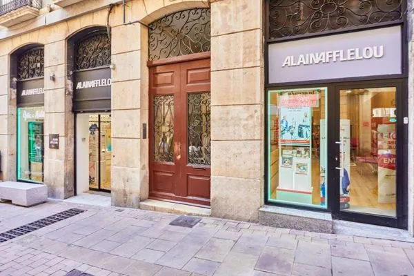 Fachada del centro auditivo Alain Afflelou Audiólogo Tarragona en la Calle Comte de Rius, equipada con tecnología avanzada para el diagnóstico y cuidado auditivo.