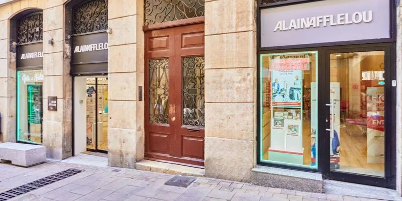 Fachada del centro auditivo Alain Afflelou Audiólogo Tarragona en la Calle Comte de Rius, equipada con tecnología avanzada para el diagnóstico y cuidado auditivo.